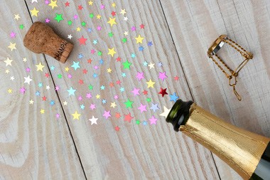 A bottle of champagne releases glitter after being popped open