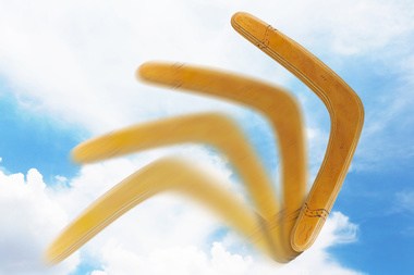 A stop-motion photo of a boomerang against a cloudy blue sky