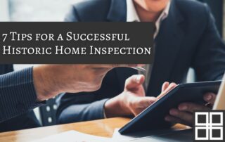Two professionals reviewing documents during a historic home inspection meeting, with a tablet and clipboard on the table.