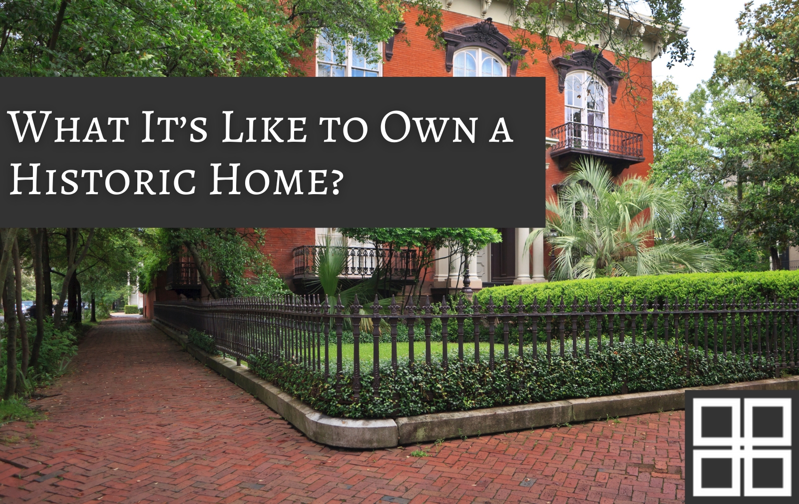 Classic historic home in Savannah, Georgia with red brick exterior, wrought-iron fence, palm trees, and a brick walkway in a tree-lined district.