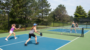 Active residents playing pickleball on one of the eight courts, while others gather around a cozy firepit at The Fish Camp boathouse.